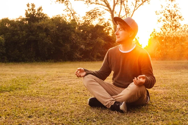 Homem Bonito Novo Uma Posição Meditative Senta Gramado Fundo Floresta — Fotografia de Stock