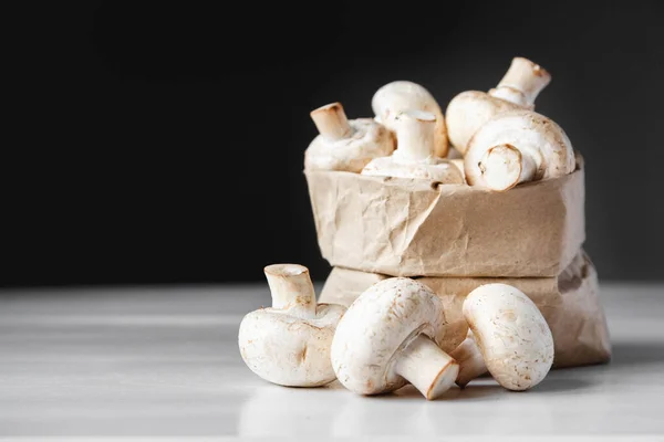 Cogumelos Champinhons Saco Papel Uma Mesa Madeira Branca Fundo Escuro — Fotografia de Stock