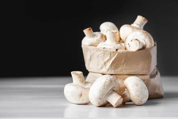 Champignons Papiertüten Auf Einem Weißen Holztisch Vor Dunklem Hintergrund Platz — Stockfoto