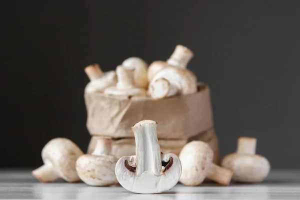 Cogumelos Champinhons Saco Papel Uma Mesa Madeira Branca Fundo Escuro — Fotografia de Stock