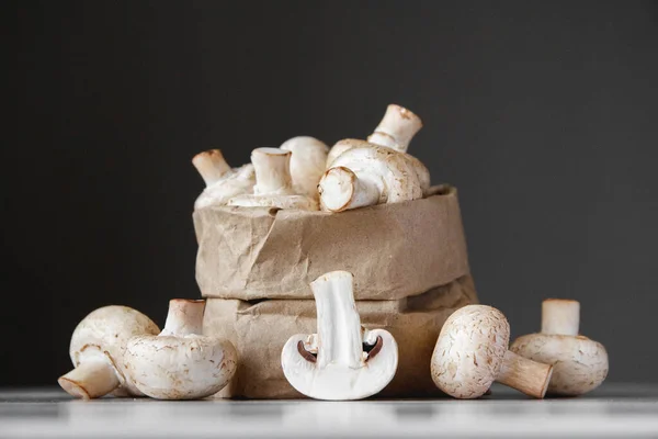 Paddenstoelen Champignons Papieren Zak Een Witte Houten Tafel Een Donkere — Stockfoto