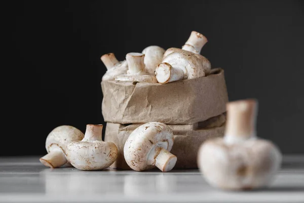 Paddenstoelen Champignons Papieren Zak Een Witte Houten Tafel Een Donkere — Stockfoto