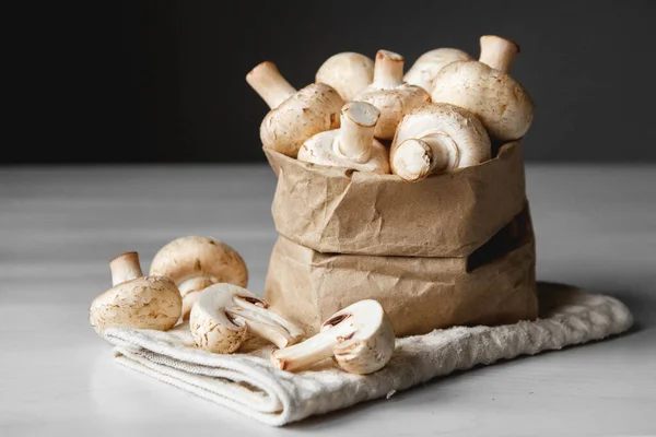 Paddenstoelen Champignons Papieren Zak Een Witte Houten Tafel Een Donkere — Stockfoto