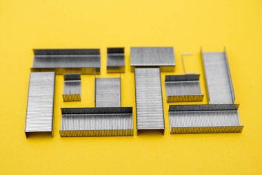 Sarı arka planda zımba için metal zımbalar. Üst Manzara. Minimalist bir kavram. Kopyala, metin için boşluk.