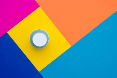 Çok renkli arka planda tek kullanımlık mavi kağıt bardak. Üst Manzara. Minimalist stil. Kopyala, metin için boşluk.