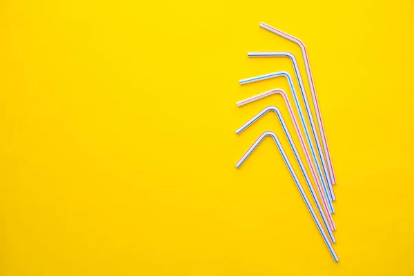 Drinking plastic straws on a yellow background. Colorful of plastic straws used for drinking water or soft drinks. Top view. Minimalist Style. Copy, empty space for text.