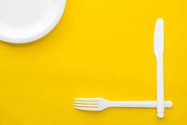 塑料白色叉子 刀盘在黄色背景上 顶部视图 简约主义风格 空的文字空间 — 图库照片