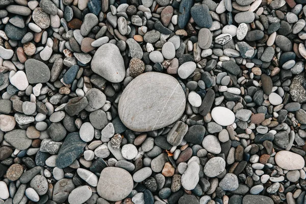 Gravel pattern of wet colored stones. Abstract nature pebbles background. Stone background. Sea peblles beach. Top view.