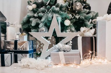 Aydınlatılmış köknar ağacı ve güzel bir noel ağacının altında hediyeler.