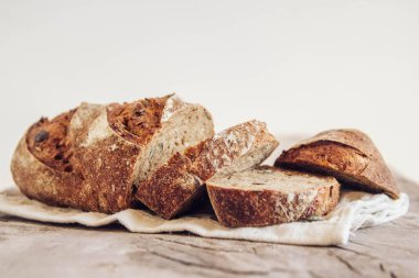 Tohumlu kahverengi taze ekmek eski ahşap arka planda parçalara ayrılır. Kopyala, metin için boşluk.