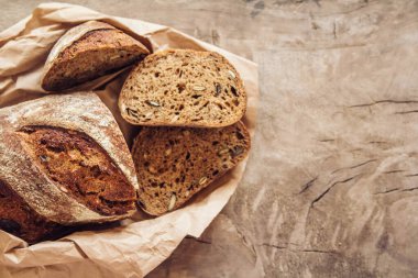 Tohumlu kahverengi taze ekmek eski ahşap arka planda parçalara ayrılır. Kopyala, metin için boşluk.