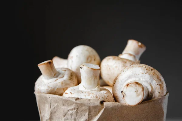 Cogumelos Champinhons Saco Papel Fundo Escuro Fecha Lugar Para Texto — Fotografia de Stock