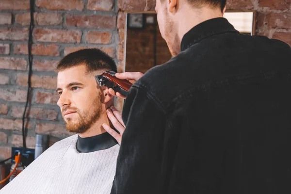 Joven Peluquero Macho Afeita Cabeza Del Cliente Con Trimmer Eléctrico — Foto de Stock