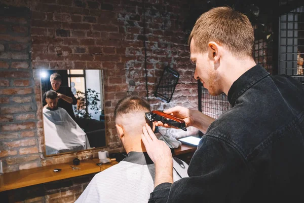 Joven Peluquero Macho Afeita Cabeza Del Cliente Con Trimmer Eléctrico — Foto de Stock