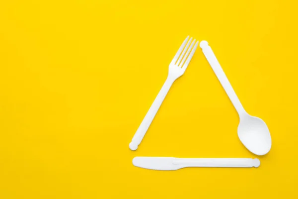 Plastic White Fork Knife Spoon Form Triangle Yellow Background Cooking — Stock Photo, Image