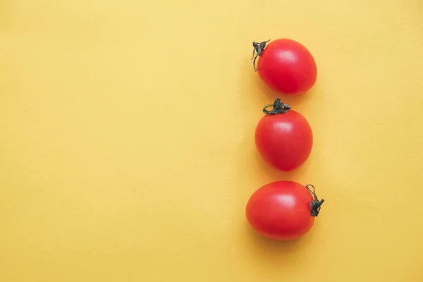 黄色の背景に赤いトマトの野菜 最上階だ ミニマリストスタイル テキストのコピー 空のスペース — ストック写真