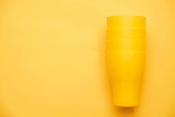 Sarı Arka Planda Sarı Plastik Bardaklar Mutfak Aletleri Üst Manzara — Stok fotoğraf
