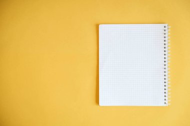 Sarı arka plana yazmak için boş bir defter. Üst Manzara. Kopyala, metin için boşluk.
