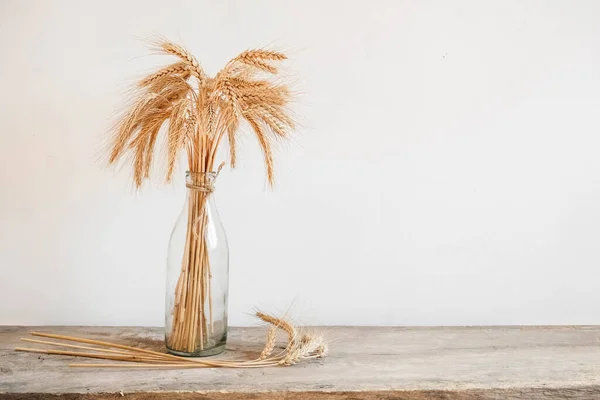 木製のテーブルの上のガラス花瓶に小麦の耳 テキストのコピー 空のスペース — ストック写真