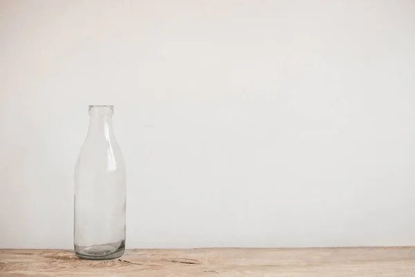 Bottiglia Vetro Trasparente Tavolo Legno Sfondo Bianco Parete Copia Spazio — Foto Stock