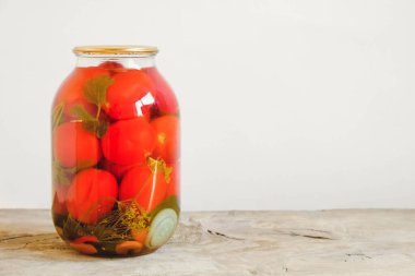 Ahşap masada cam kavanozlarda domates turşusu. Kopyala, metin için boşluk.