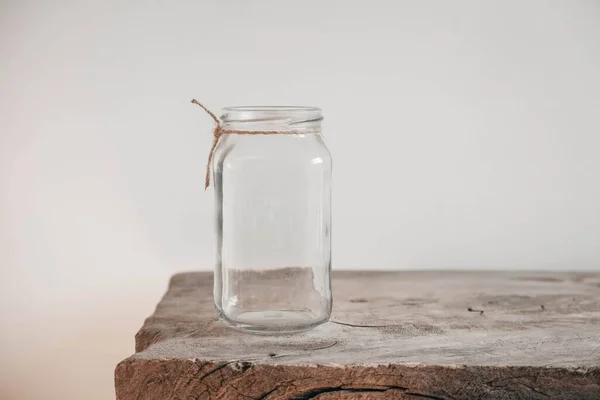 白い壁の背景に木製のテーブルの上にガラス透明瓶 テキストのコピー 空のスペース — ストック写真