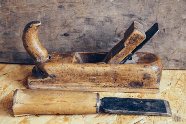 Old construction tools on a wooden workbench flat lay background. Carpenter table. Woodwork.