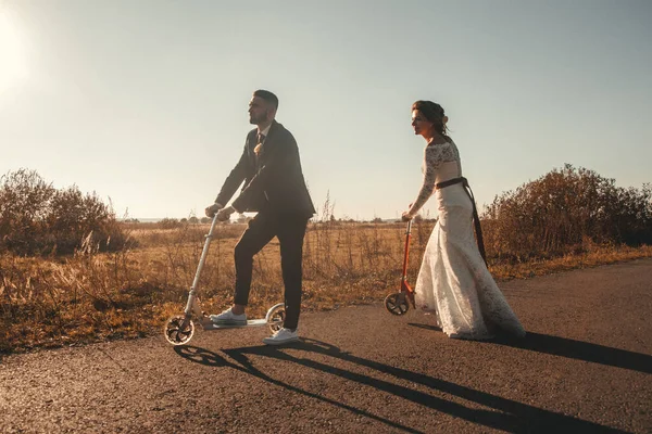 Lächelndes Hochzeitspaar Auf Einem Motorroller Auf Der Straße Vor Den — Stockfoto