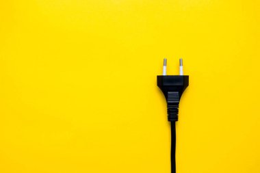 Sarı arka planda siyah elektrik prizi konnektörü. Üst Manzara. Kopyala, metin için boşluk.