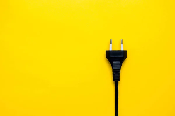 stock image Black electric plug connector on yellow background. Top view. Copy, empty space for text.