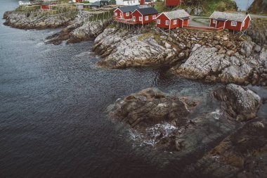 Norveç evleri ve dağları fiyort üzerindeki kayalar İskandinav seyahat manzarası Lofoten adaları.
