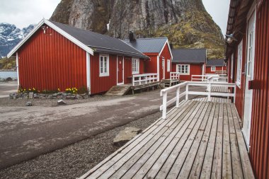 Norveç evleri ve dağları fiyort üzerindeki kayalar İskandinav seyahat manzarası Lofoten adaları.