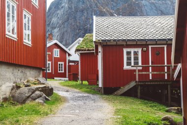 Norveç evleri ve dağları fiyort üzerindeki kayalar İskandinav seyahat manzarası Lofoten adaları.