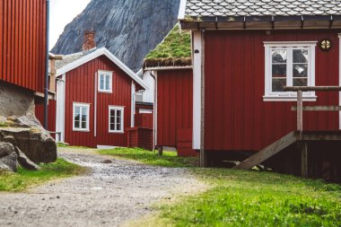 Norveç evleri ve dağları fiyort üzerindeki kayalar İskandinav seyahat manzarası Lofoten adaları.