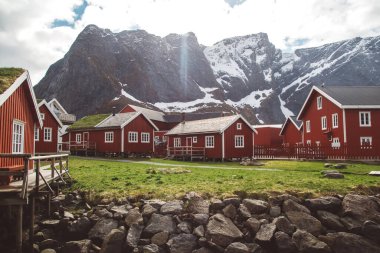 Norveç evleri ve dağları fiyort üzerindeki kayalar İskandinav seyahat manzarası Lofoten adaları.