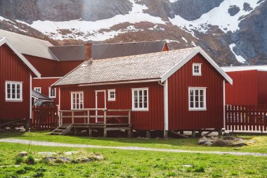 Norveç evleri ve dağları fiyort üzerindeki kayalar İskandinav seyahat manzarası Lofoten adaları.