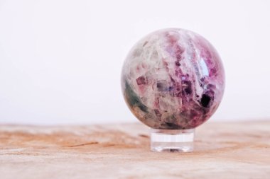 Crystal in the form of ball on a wooden table. Copy, empty space for text. clipart