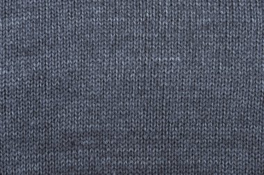 Arka plan görüntüsü olarak gri örülmüş maddenin dokusu. Örgü iğnelerinin üzerine örgü örüyorum. Üst Manzara. Kopyala, metin için boşluk.