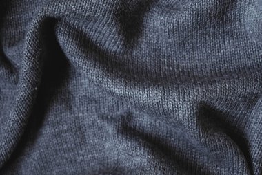 Arka plan görüntüsü olarak gri örülmüş maddenin dokusu. Örgü iğnelerinin üzerine örgü örüyorum. Üst Manzara. Kopyala, metin için boşluk.