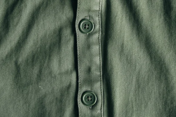 Green buttons on green jacket. Clothing detail. Top view. Copy, empty space for text.