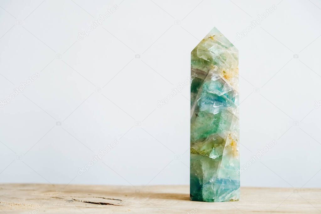 Raw emerald and gemstone rough rock crystal on a wooden table. Copy, empty space for text.