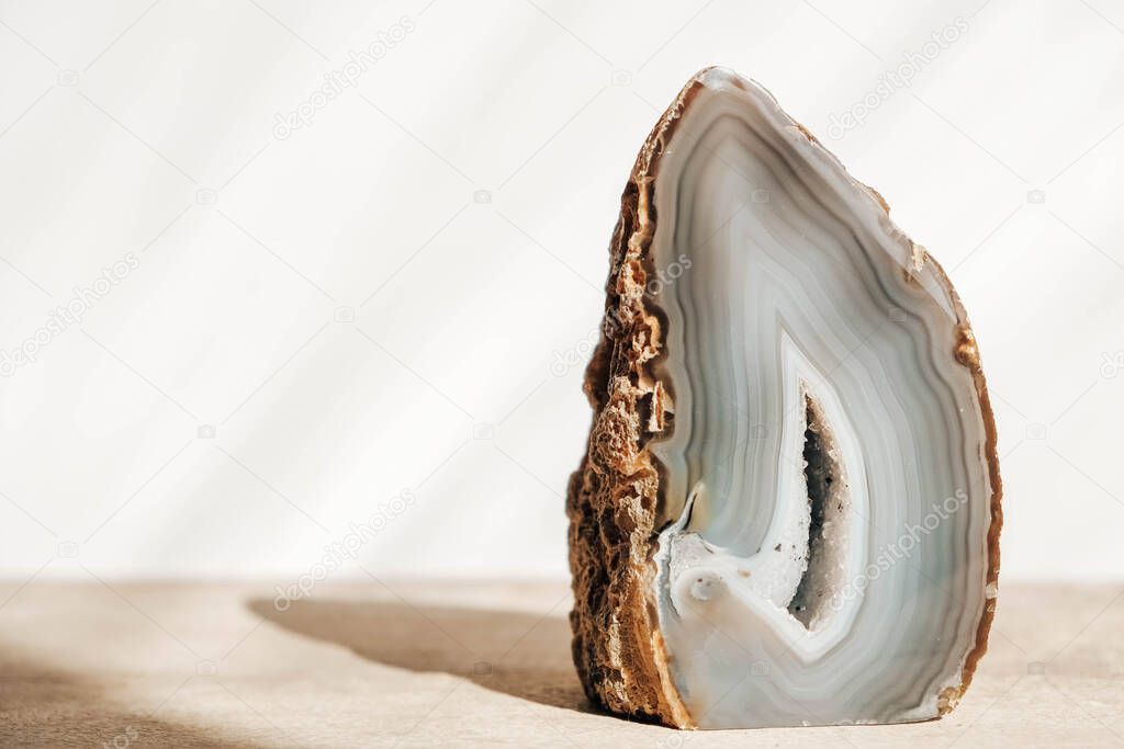 A polished agate mineral on a wooden table. Copy, empty space for text.