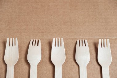 Tahta çatallar karton arka planda. Çevre dostu tek kullanımlık sofra takımı. Üst Manzara. Kopyala, metin için boşluk.