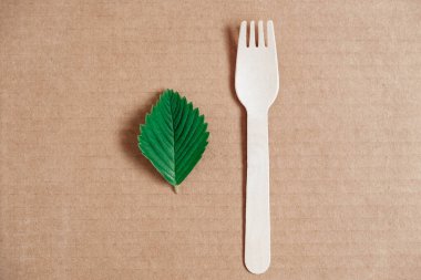 Karton arka planda ahşap çatal. Çevre dostu tek kullanımlık sofra takımı. Üst Manzara. Kopyala, metin için boşluk.