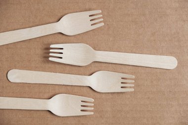 Tahta çatallar karton arka planda. Çevre dostu tek kullanımlık sofra takımı. Üst Manzara. Kopyala, metin için boşluk.