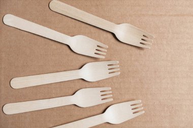 Tahta çatallar karton arka planda. Çevre dostu tek kullanımlık sofra takımı. Üst Manzara. Kopyala, metin için boşluk.