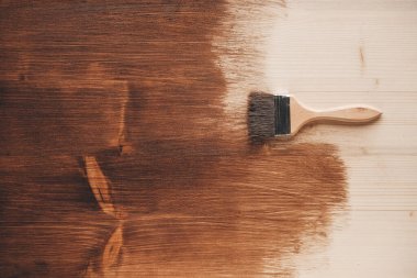 Ahşap saplı fırça ve kahverengi ahşap kaplamaların arka planında doğal kıllar. Tamir konsepti. Üst Manzara. Kopyala, metin için boşluk.