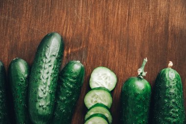 Ahşap zemin üzerinde taze salatalık dilimleri. Üst Manzara. Kopyala, metin için boşluk.