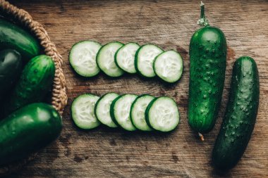 Ahşap zemin üzerinde taze salatalık dilimleri. Üst Manzara. Kopyala, metin için boşluk.