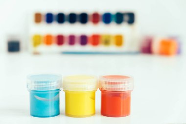 Renkli guache boyaları ve beyaz ahşap masadaki boya için fırça. Kopyala, metin için boşluk.